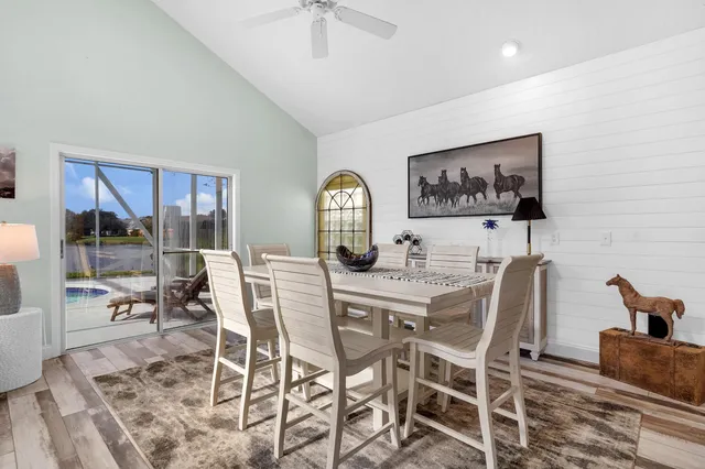 a view of a dining room with furniture wooden floor and a floor to ceiling window