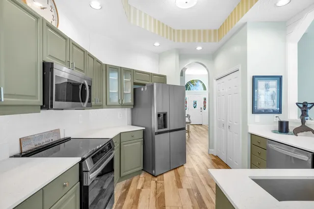 a kitchen with stainless steel appliances granite countertop a refrigerator a stove and a sink