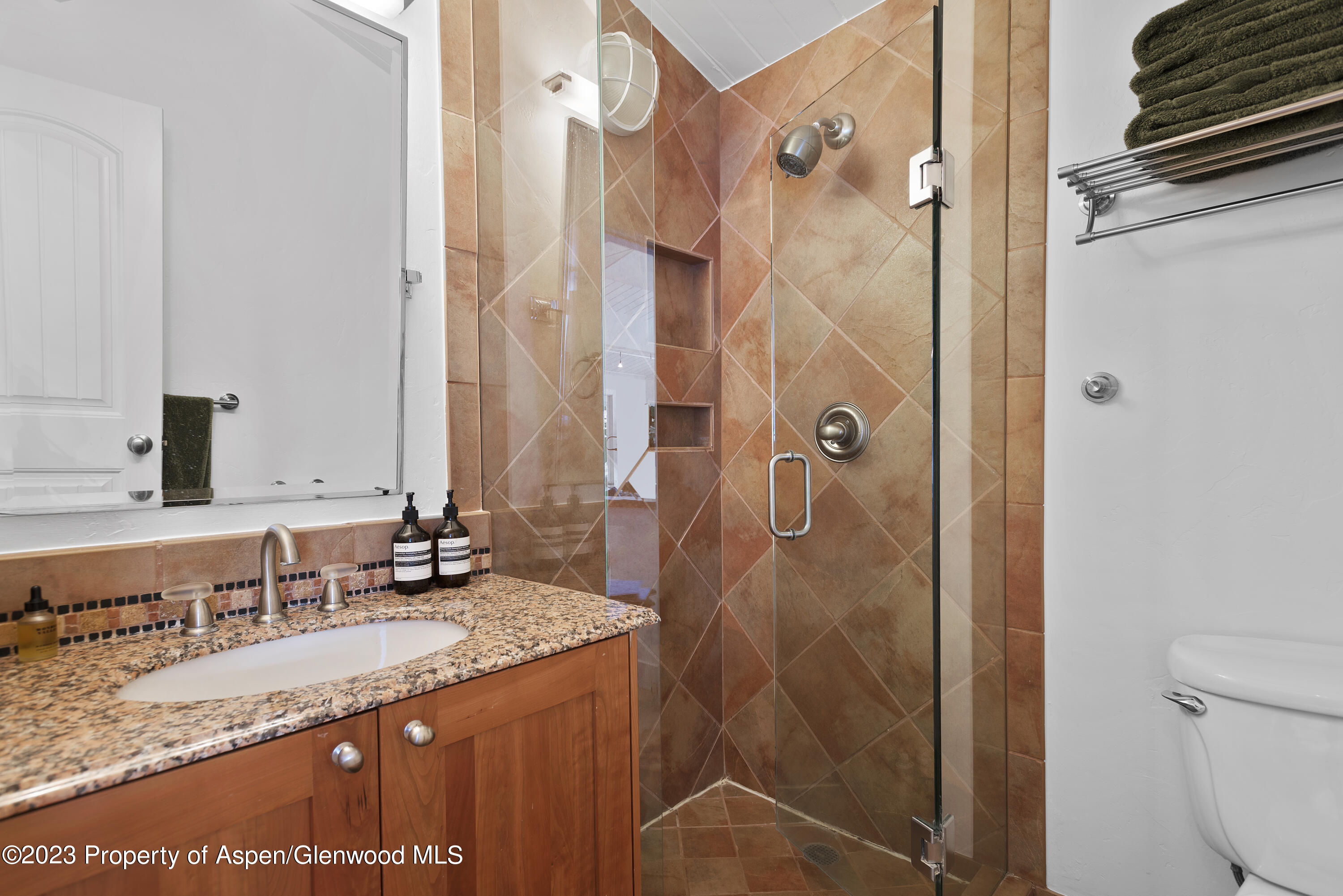 809 South Aspen Street, Unit 17 Aspen, CO 81611 - Photo 22 of 34 a bathroom with a granite countertop sink a mirror and shower