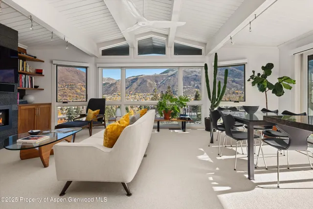 a living room with furniture and floor to ceiling windows