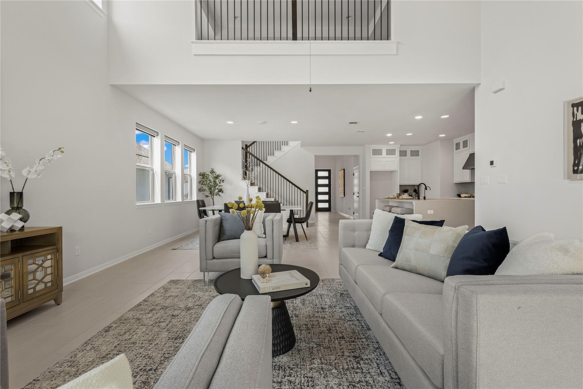 1128 Villa Rialto View Leander, TX 78641 - Photo 19 of 40 An open concept living area boasts a soaring ceiling and a modern staircase.