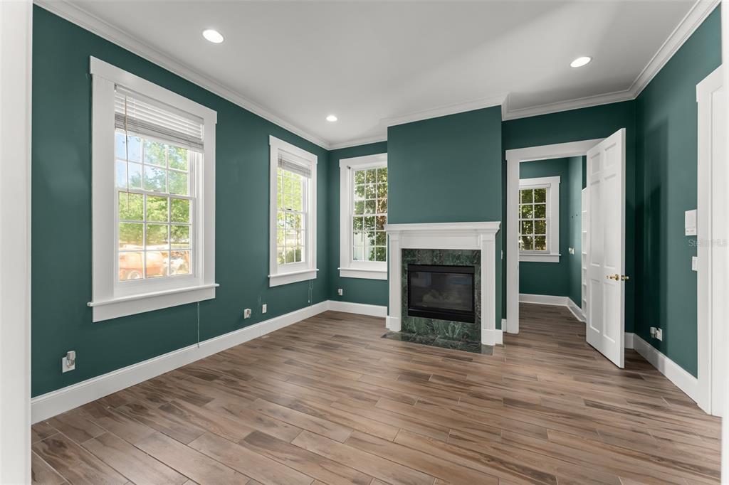 403 Water Street Celebration, FL 34747 - Photo 9 of 86 an empty room with large windows a fireplace and a chandelier