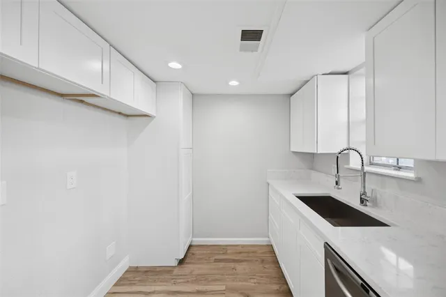 a kitchen with a sink a refrigerator and cabinets