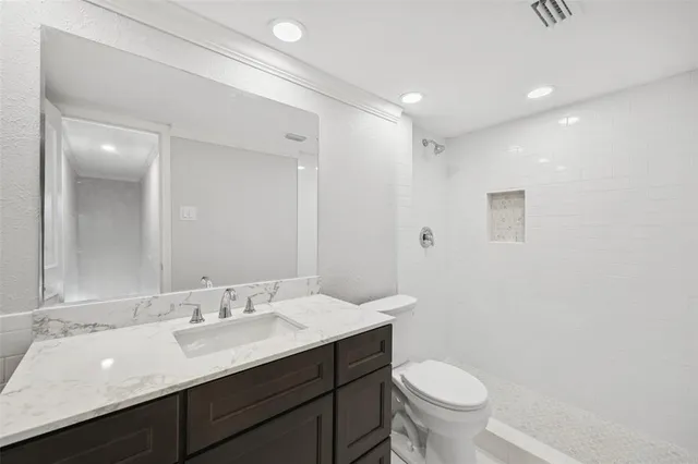 a bathroom with a double vanity sink toilet and a mirror