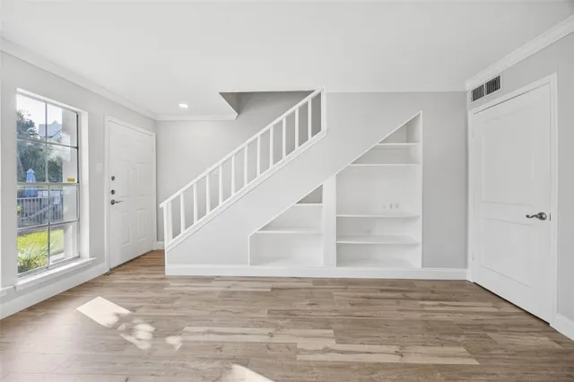 a view of entryway and hall with wooden floor