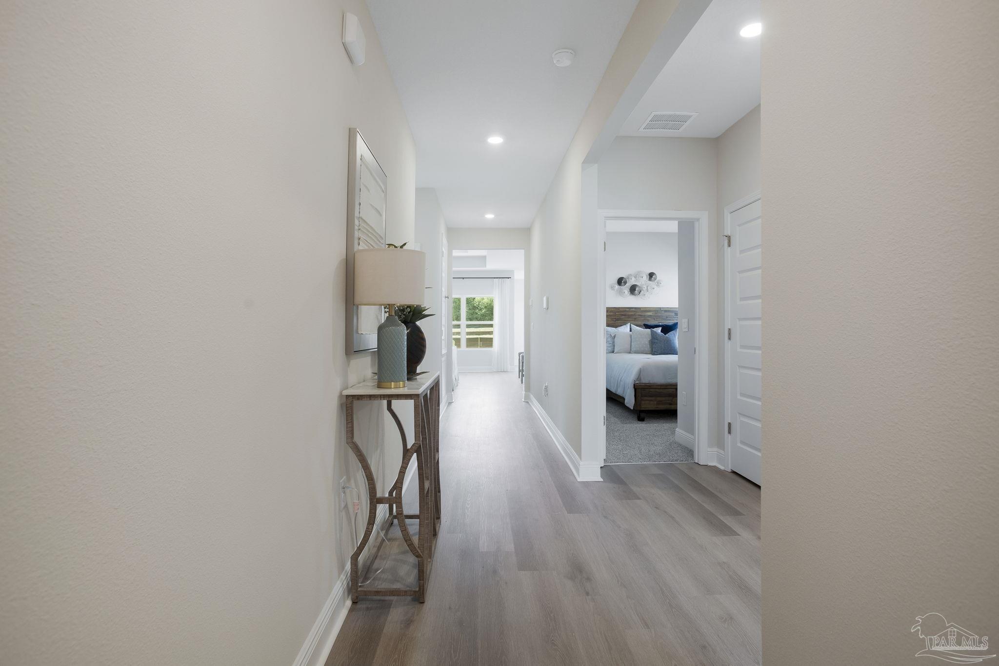 3298 Water Birch Road Cantonment, FL 32533 - Photo 5 of 40 a view of a hallway with wooden floor and a bathroom
