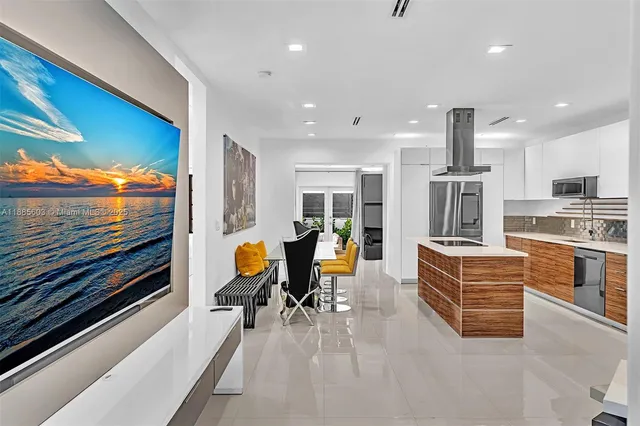 a kitchen with stainless steel appliances kitchen island granite countertop a sink and white cabinets