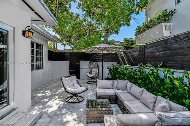 a view of a patio with couches chairs and umbrella