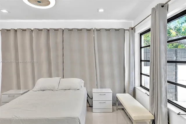 a view of an empty room with window and cabinet