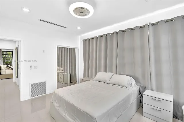 a bedroom with a bed and a large window