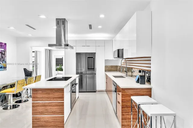 a kitchen with stainless steel appliances kitchen island granite countertop a stove and a refrigerator