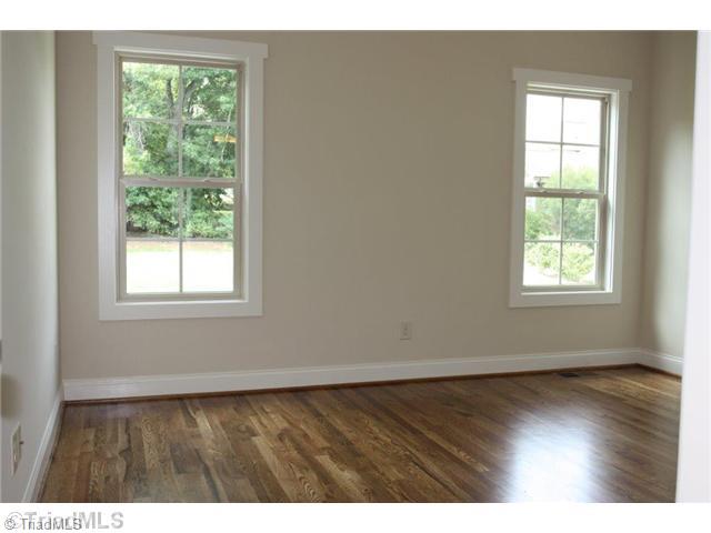 8902 West Pepper Court Oak Ridge, NC 27310 - Photo 11 of 16 2nd Bedroom. There is a second bedroom on the main level. This one is located on the other side of the home from the master, and has hardwood floors, direct bath access and crown molding.