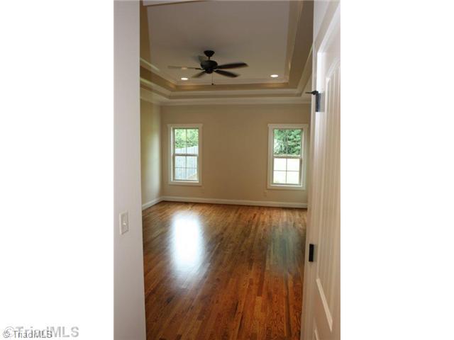 8902 West Pepper Court Oak Ridge, NC 27310 - Photo 6 of 16 Master Bedroom. The hardwood floors continue into the main level Master. Note the recessed lights, double tray ceiling detail and special trim details.