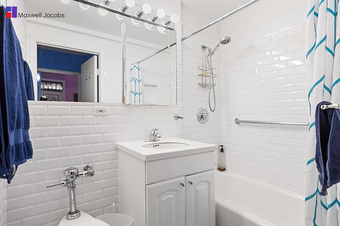 45 West 54th Street, Unit 3C Manhattan, NY 10019 - Photo 11 of 13 a bathroom with a sink a mirror and a shower