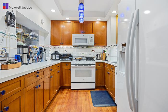 45 West 54th Street, Unit 3C Manhattan, NY 10019 - Photo 4 of 13 a kitchen with granite countertop a sink stainless steel appliances and cabinets