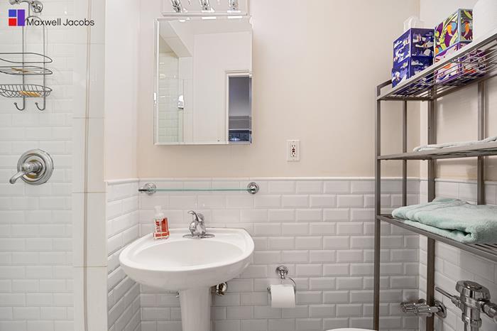 45 West 54th Street, Unit 3C Manhattan, NY 10019 - Photo 8 of 13 a bathroom with a sink and a mirror