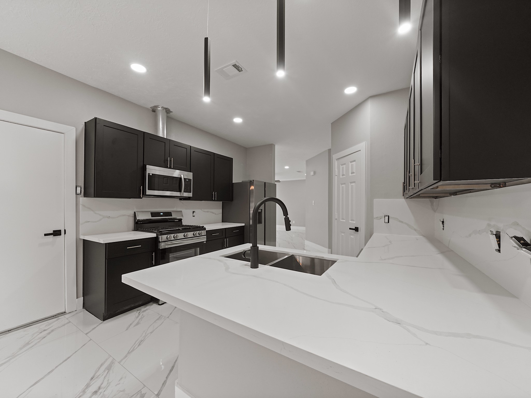 25007 Butterwick Drive Spring, TX 77389 - Photo 7 of 22 a kitchen with stainless steel appliances kitchen island a sink a stove and cabinets