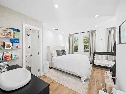 a bedroom with a bed a dresser and a large mirror