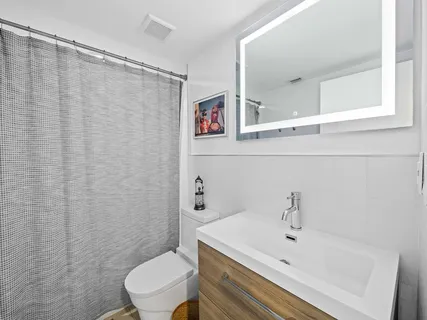 a bathroom with a sink a toilet and shower curtain