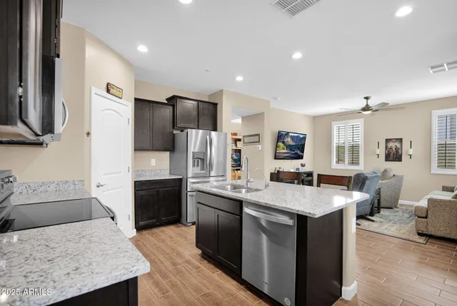 a open kitchen with stainless steel appliances granite countertop a sink stove and refrigerator