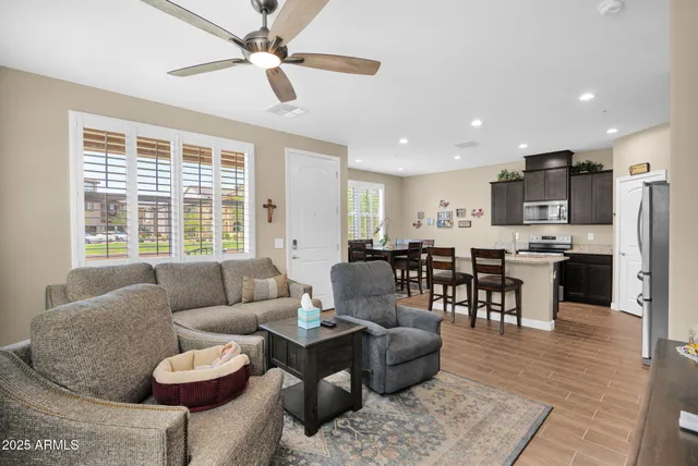 a living room with furniture kitchen and a large window