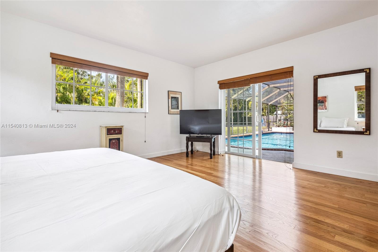 10130 Southwest 70th Avenue Pinecrest, FL 33156 - Photo 25 of 75 a spacious bedroom with a bed and wooden floor
