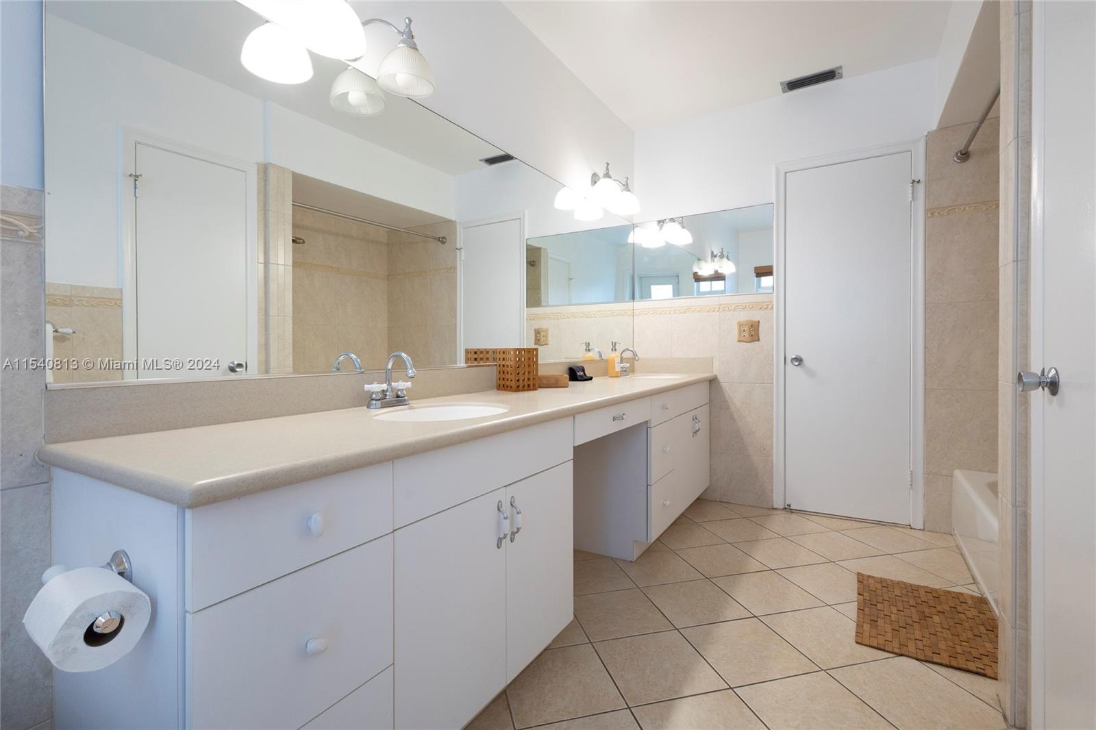 10130 Southwest 70th Avenue Pinecrest, FL 33156 - Photo 29 of 75 a bathroom with a sink a mirror and a shower