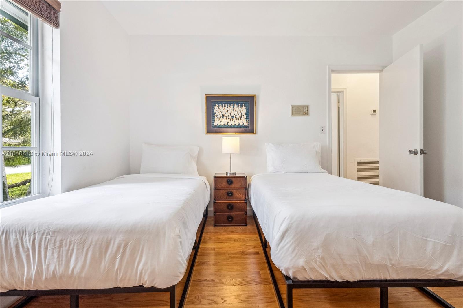 10130 Southwest 70th Avenue Pinecrest, FL 33156 - Photo 34 of 75 a bedroom with a bed and wooden floor