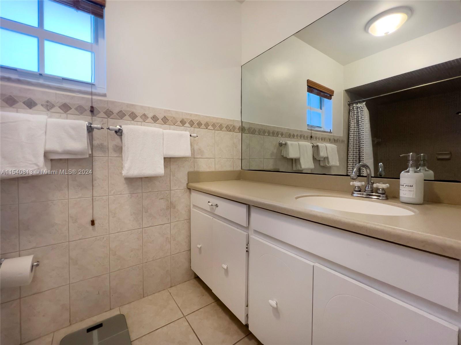 10130 Southwest 70th Avenue Pinecrest, FL 33156 - Photo 47 of 75 a bathroom with a sink and a mirror
