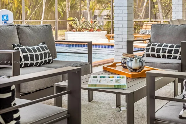 a backyard of a house with table and chairs under an umbrella