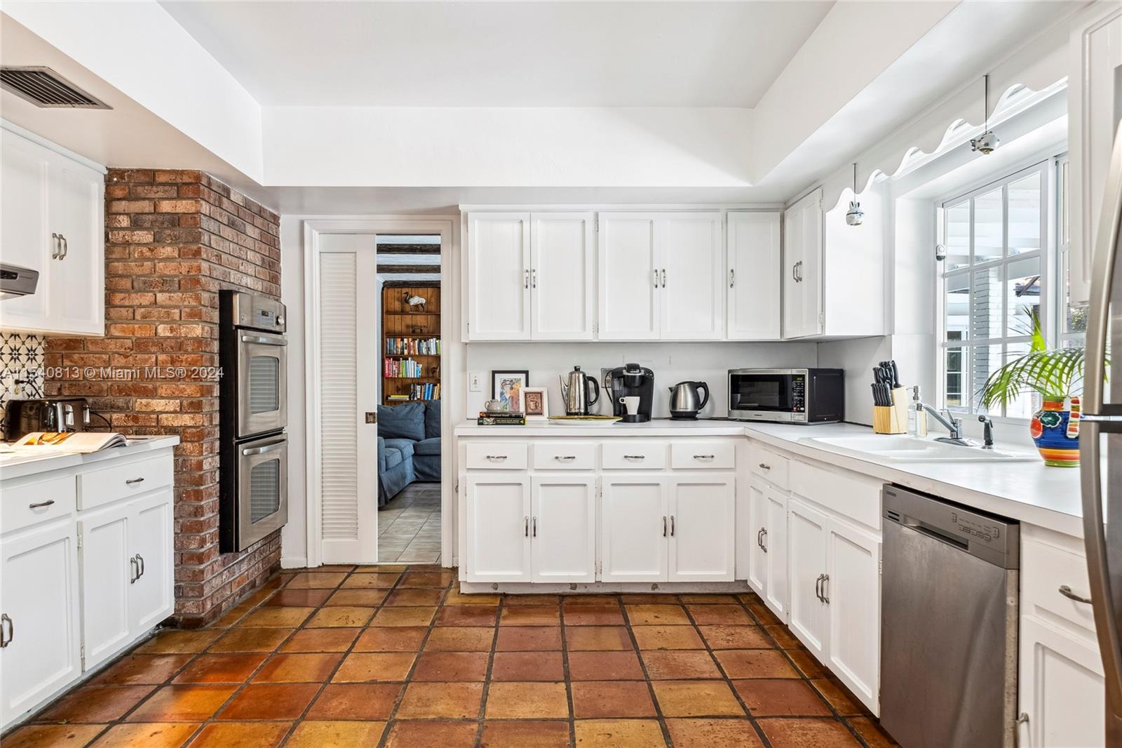 10130 Southwest 70th Avenue Pinecrest, FL 33156 - Photo 7 of 75 a large white kitchen with cabinets