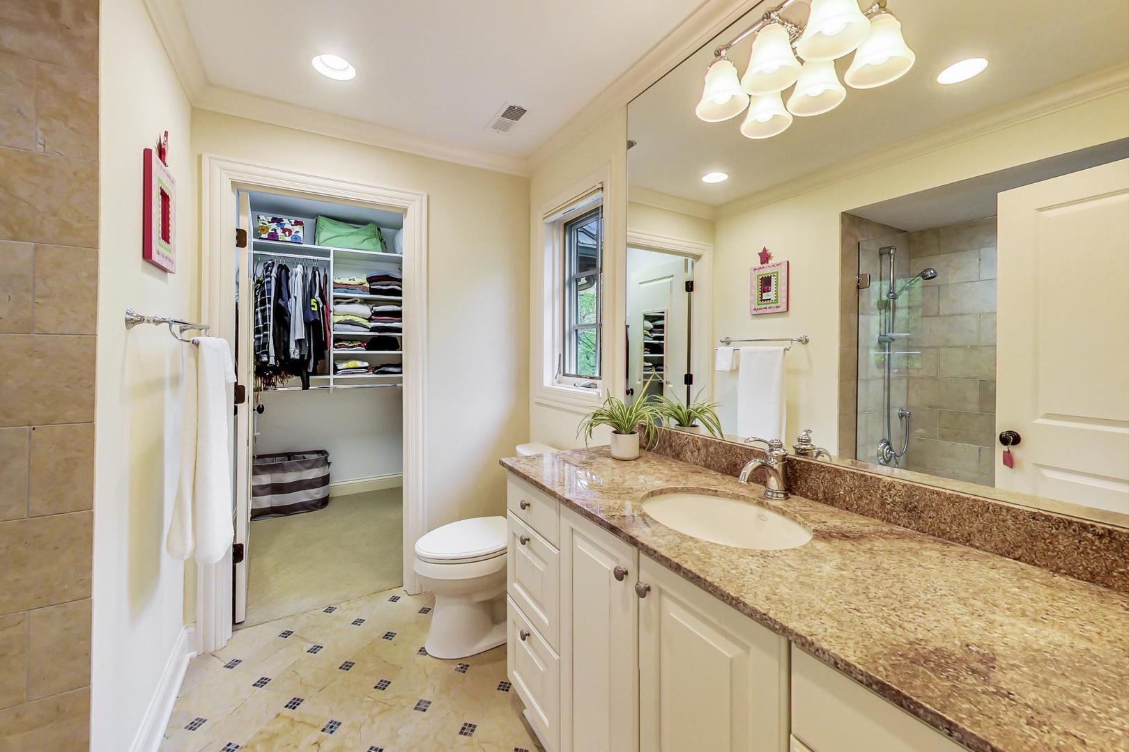 26 Timber Lane Northbrook, IL 60062 - Photo 31 of 49 a bathroom with a granite countertop sink a toilet a mirror a vanity and shower