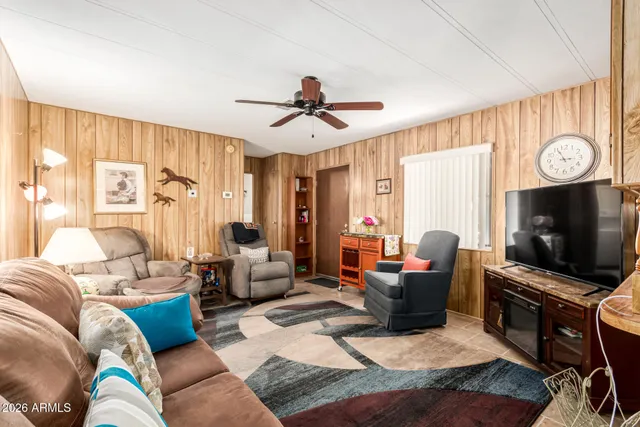 a living room with furniture a flat screen tv and a window