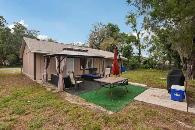 a view of a house with backyard porch and sitting area