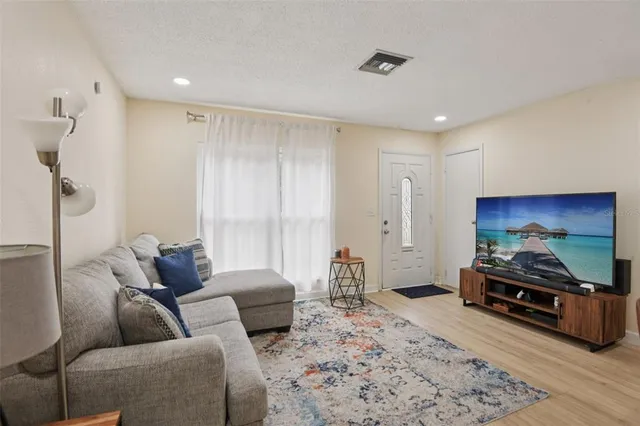 a living room with furniture a flat screen tv and a couch