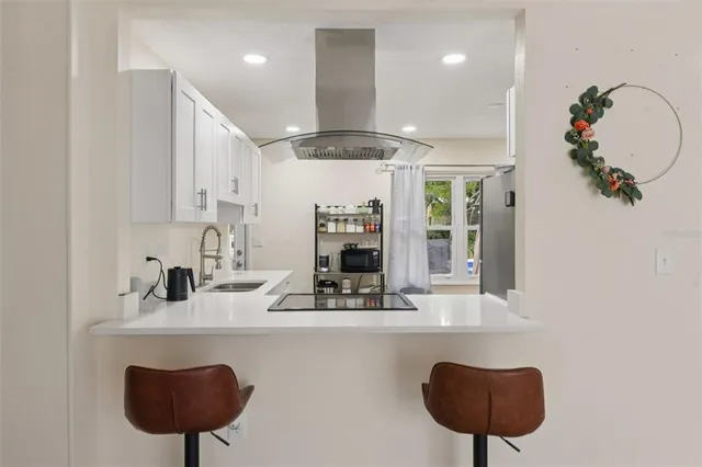 a kitchen with a refrigerator a sink and a table