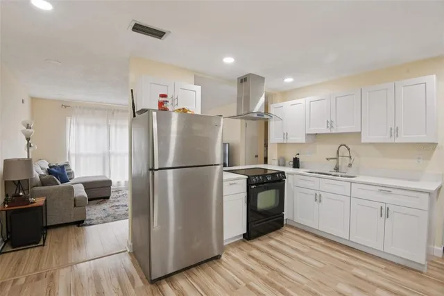 a kitchen with a refrigerator a sink and cabinets