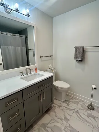 a bathroom with a toilet a sink and mirror