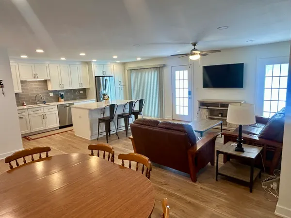a living room with furniture a flat screen tv and kitchen view