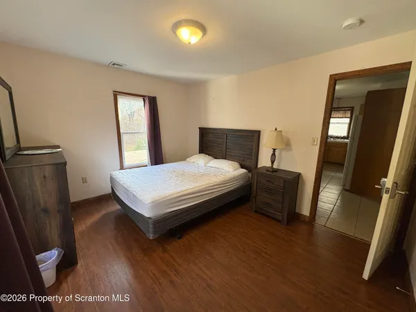 a bedroom with a bed and wooden floor