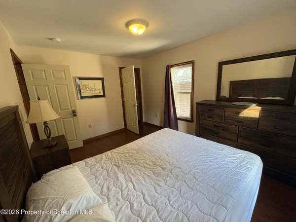 a bedroom with a bed and a flat tv screen on dresser