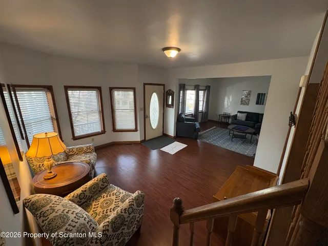 a living room with furniture and a wooden floor