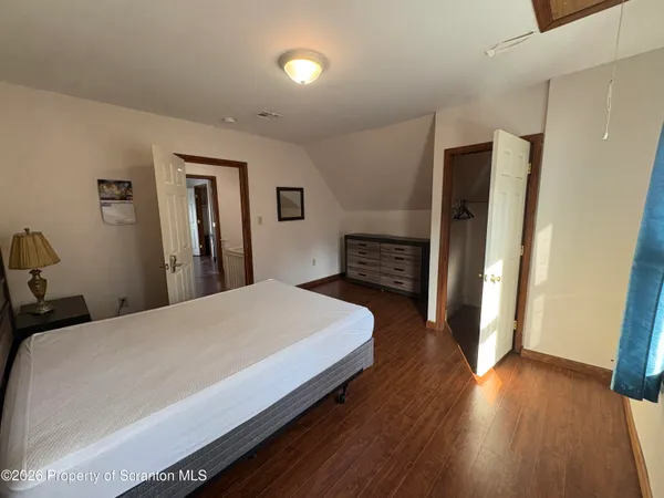 a bedroom with a bed and wooden floor