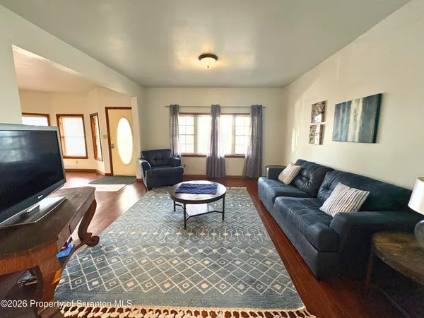 a living room with furniture a flat screen tv and a window