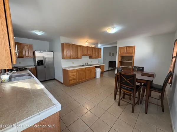 a kitchen with stainless steel appliances granite countertop a table chairs sink and cabinets