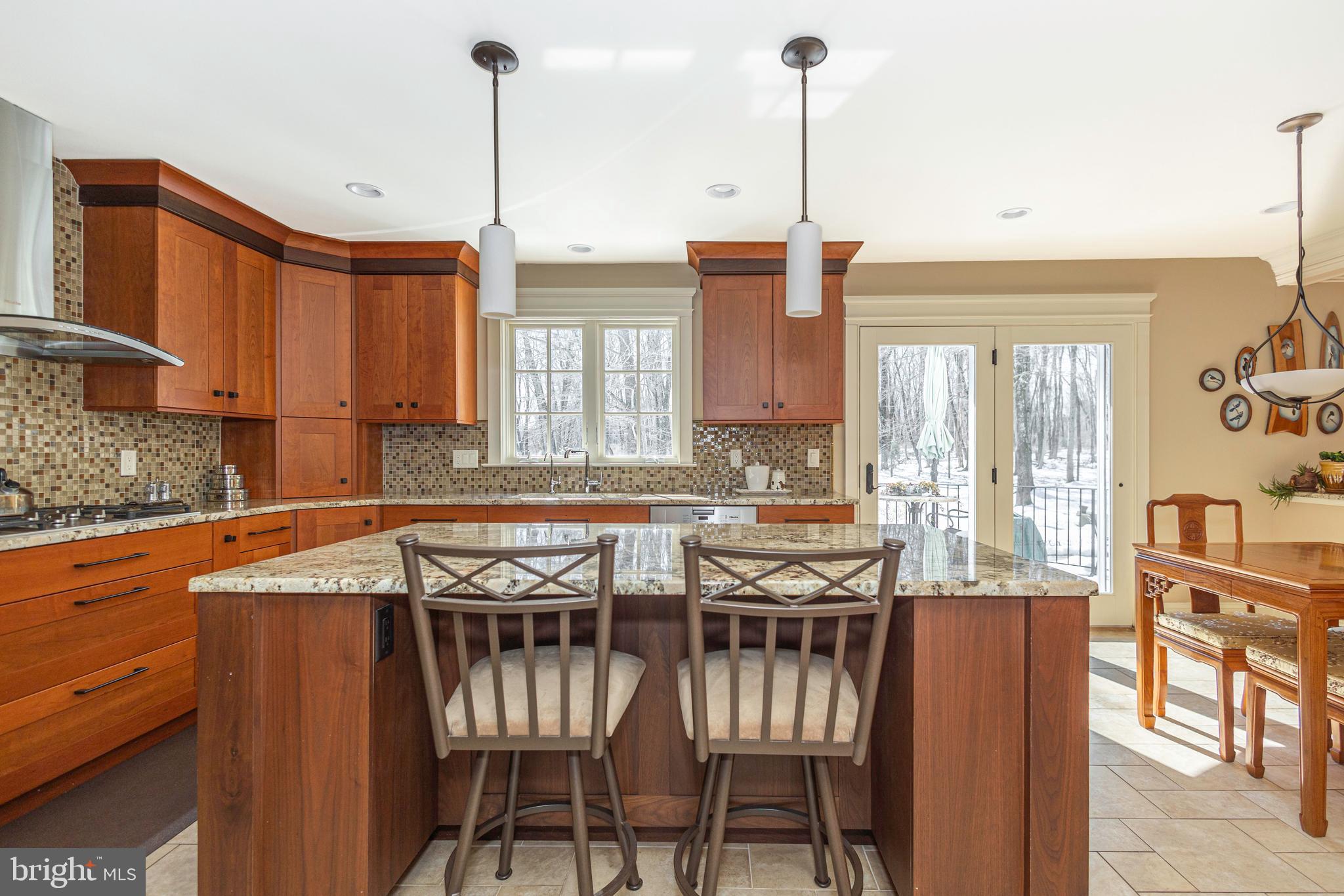 196 Aqueduct Road Washington Crossing, PA 18977 - Photo 30 of 57 a kitchen with stainless steel appliances granite countertop a stove top oven a sink with a dining table and chairs