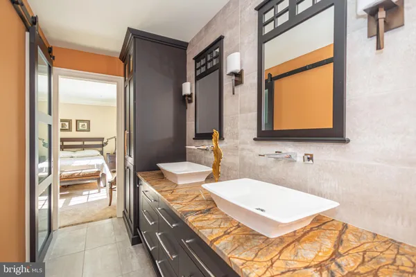 a bathroom with a granite countertop toilet sink and mirror
