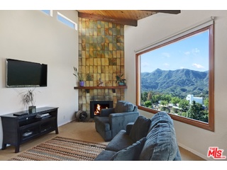 2717 Halsey Road Topanga, CA 90290 - Photo 36 of 39 a living room with furniture a flat screen tv and a fireplace