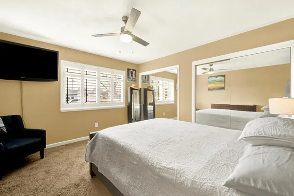 a bedroom with a bed a flat screen tv and a couch