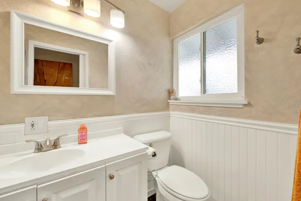 a bathroom with a sink a toilet and a window